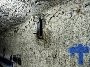 Detail jednoho zachovalého izolátoru na stěně lomené chodby.