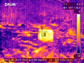 Vrchní část známého, ale v podzemí (doposud) neurčeného větracího vrtu. Vrt je zasucen = neprůchozí, ale tmavší barva materiálu (rez) způsobuje místní změnu teploty o několik desetin stupně. Výsledkem je rozdílná barva na fotografii termokamery – což je známkou toho, že ani termokamera v tomto případě nebyla všemocná. Foto: Tomáš Kos.