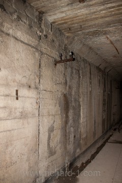 Rozmezí poválečné a válečné betonáže chodby D. Na stěnách lze spatřit obtisk bednění. Strop válečné betonáže je zajištěn pomocí železobetonových hranolů.