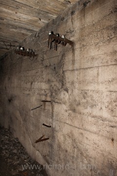 Původní izolátory ve stěnách chodby.