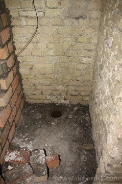 V podlaze je otvor pro nikdy neosazenou, záchodovou mísu.