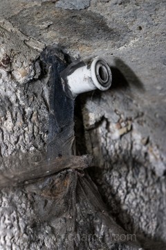 Detail jednoho zachovalého izolátoru na stěně lomené chodby.