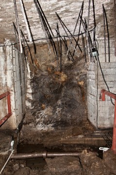 Obnažené dráty armatury a odkrytá kamenina kanalizace. Jasné známky toho, že tato část podzemí nebyla dostavěna do konečné podoby.