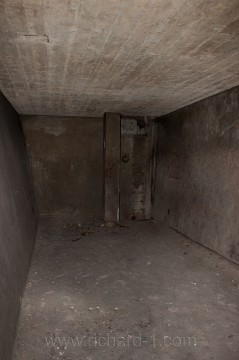Pohled do jedné ze dvou nádrží na pitnou vodu. Levá stěna nádrže je šikmá. V zadní části fotografie jsou vedle betonového sloupu ocelové schůdky.