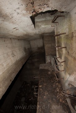 Rampa pod ocelovými vstupními schody. Otvory po pravé straně pokračují do nádrží na pitnou vodu. Schody po straně levé vedou do spodního patra, kde stávala technologie.