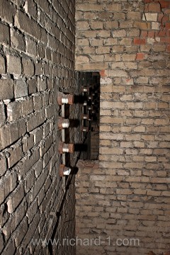 Průchod dělicí zdí a zachovalé izolátory vysokého napětí.