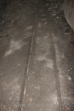 Páteřní chodba D – Koleje zapuštěné na úroveň betonové podlahy.