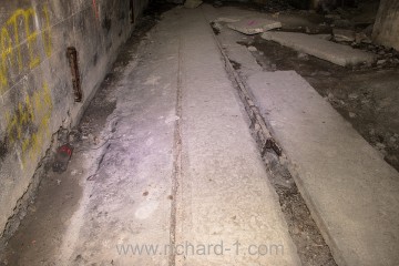 Páteřní chodba D – Koleje zapuštěné na úroveň betonové podlahy.