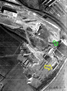 Letecká fotografie z března 1945. Žlutá šipka označuje budovu krematoria, zelená šipka budovu cihelny.
